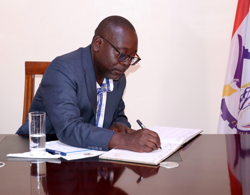 Mr. Shem Nyakutu signing the Vice Chancellor's visitors book 